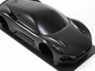 Een strak, zwart Maserati Grecale-model, weergegeven op een vlakke standaard tegen een witte achtergrond.