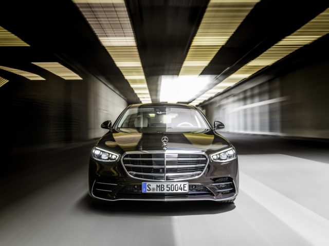 Een zwarte Mercedes-Benz S-Klasse-auto die door een tunnel snelt met bewegingsonscherpte op de lichten erboven.