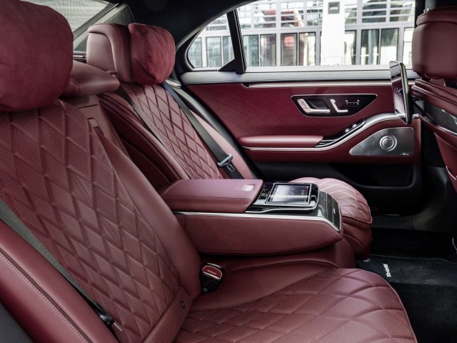 Luxueus Mercedes-Benz S-Klasse-interieur met roodleren stoelen, houten paneelaccenten en geavanceerde dashboardbediening.