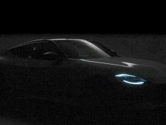 Een slecht verlichte afbeelding van een Nissan Z met gloeiende blauwe koplampen, die een strak en modern ontwerp benadrukt, tegen een donkere achtergrond.