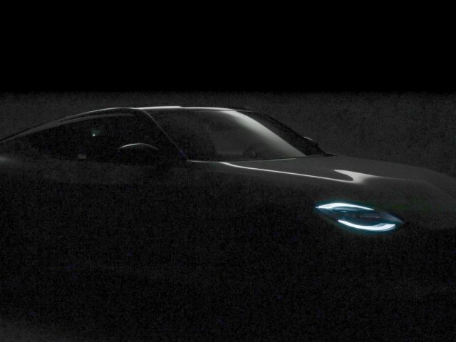 Een slecht verlichte afbeelding van een Nissan Z met gloeiende blauwe koplampen, die een strak en modern ontwerp benadrukt, tegen een donkere achtergrond.