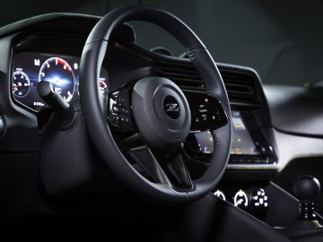 Binnenaanzicht van de Nissan Z Proto met de nadruk op het stuur en het dashboard, met verlichte bedieningselementen en digitale displays.
