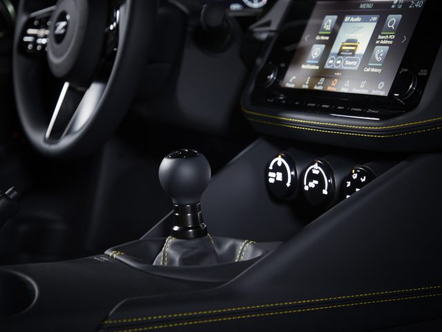 Binnenaanzicht van de Nissan Z Proto met een handmatige versnellingspook, dashboard met touchscreendisplay en stuurwiel.