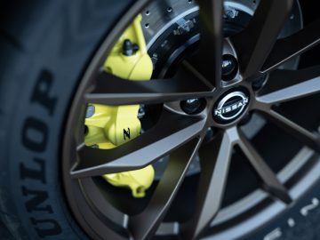 Close-up van een Nissan Z Proto-autowiel met Dunlop-band en gele remklauw.