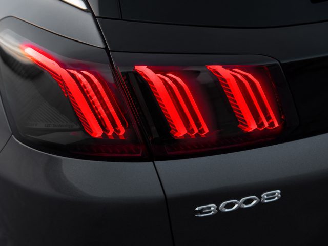 Close-up van de rode achterlichten en het modelembleem op een zwarte Peugeot 3008.