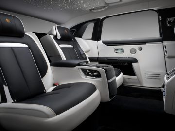 Luxe Rolls-Royce Ghost-interieur met zachte lederen stoelen, hemelbekleding met sterrenlicht en elegante houtaccenten.