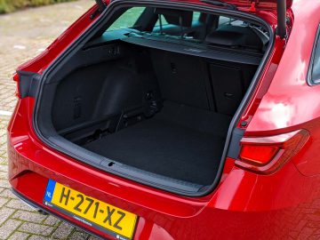 Open kofferbak van een rode Seat Leon Sportstourer met een schone en lege laadruimte.