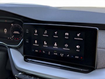 Autodashboarddisplay in een Skoda Octavia met multimedia- en navigatieopties, met pictogrammen voor radio, navigatie en instellingen in een modern voertuiginterieur.
