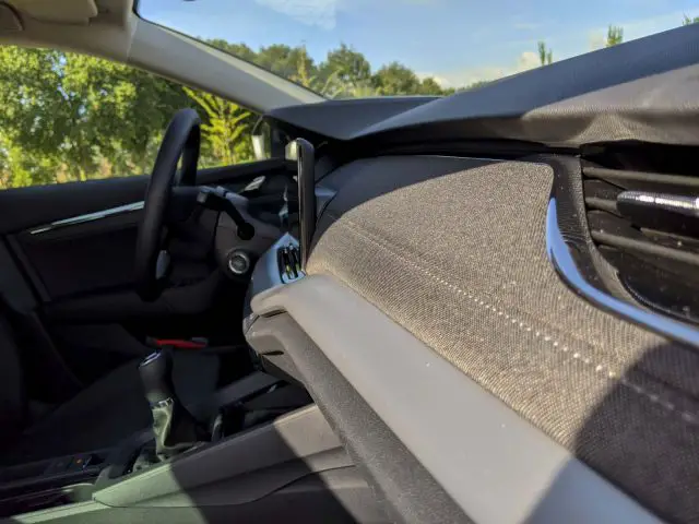 Binnenaanzicht van een Skoda Octavia vanaf de passagierszijde, met het dashboard, het stuur en de bestuurdersstoel met de deur open.