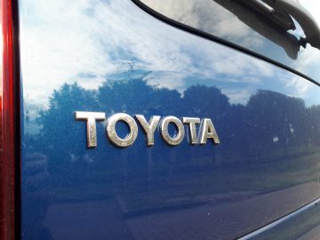 Close-up van een Toyota ProAce City Verso-logo op het blauwe metalen oppervlak van een auto.
