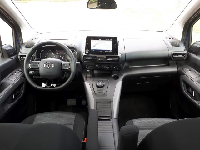 Binnenaanzicht van een Toyota ProAce City Verso, met het stuur, het dashboard, de middenconsole en de voorstoelen.