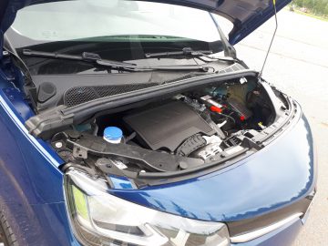 Open motorkap van een blauwe Toyota ProAce City Verso met een gedetailleerd zicht op de motorruimte met verschillende zichtbare componenten.