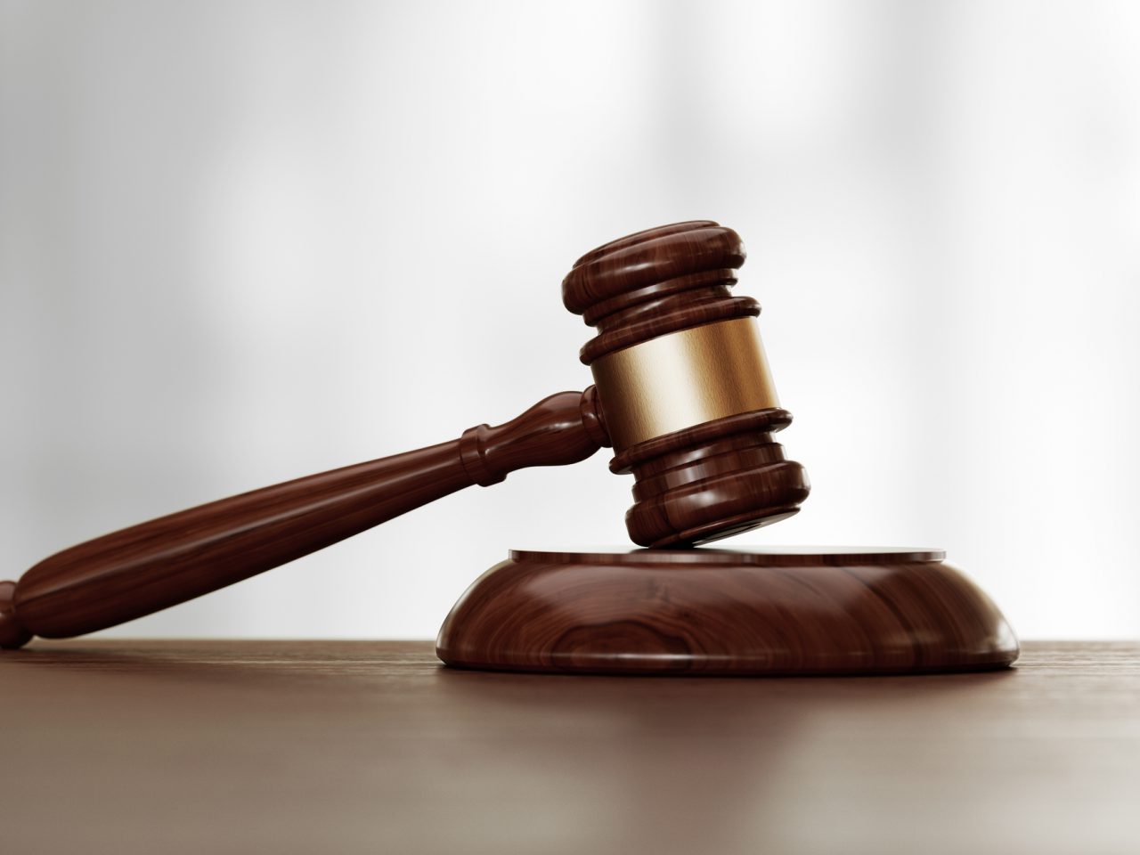 Houten rechtershamer op een bureau met een onscherpe achtergrond, symbool voor juridische autoriteit en gerechtelijke procedures waarmee een recordbedrag gemoeid is.