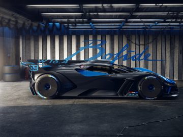 Een strakke zwarte Bugatti Bolide-sportwagen geparkeerd in een garage, die het futuristische ontwerp en de aerodynamische structuur laat zien.