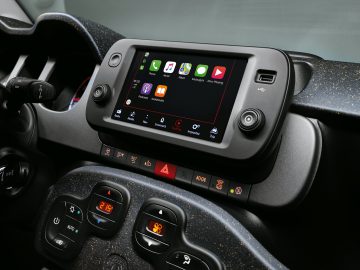 Autodashboard met touchscreen-display met verschillende app-pictogrammen, omgeven door bedieningsknoppen en een gespikkelde afwerking in de Fiat Panda Sport.