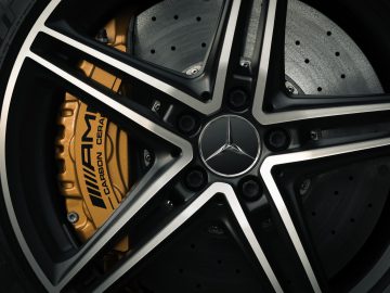 Close-up van een Mercedes-AMG GT C Roadster-wiel met het gedetailleerde ontwerp van de velg, remklauw en geventileerde schijf.