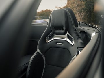 Binnenaanzicht van een Mercedes-AMG GT C Roadster met de nadruk op een zwartleren sportstoel met eigentijdse designelementen.