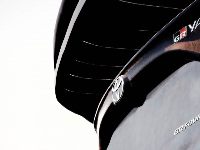 Gedetailleerde close-up van een Toyota GR Yaris Rally Concept met de nadruk op de achtervleugel, voorzien van het logo, tegen een lichte achtergrond.