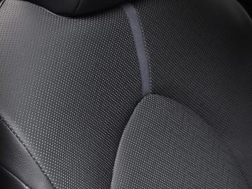 Close-up van een zwarte Toyota Camry-autostoel met gedetailleerde stiksels en geperforeerde lederen bekleding.