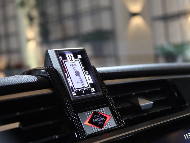 Digitaal autodashboarddisplay met een navigatiekaart, met een rode "motorstop"-knop zichtbaar onder het scherm in de DS 9.
