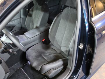 Binnenaanzicht van de DS 9 met de bestuurdersstoel, deur en stuur, met donkere bekleding en goed onderhouden details.
