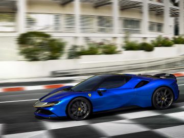 Een blauwe Ferrari SF90 Spider snelt over een stedelijke weg en toont bewegingsonscherpte tegen een achtergrond van moderne gebouwen en vangrails.