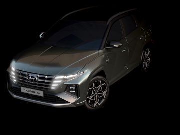 Een zilveren Hyundai Tucson SUV, schuin geplaatst op een zwarte achtergrond, wat het strakke ontwerp en de moderne kenmerken benadrukt.