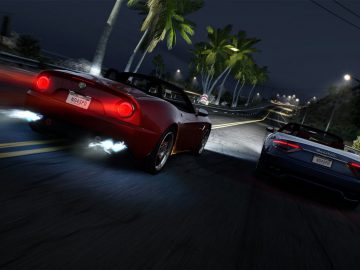 Twee sportwagens racen 's nachts op een kustweg omzoomd met palmbomen, verlicht door straatlantaarns en hun koplampen, die doen denken aan een scène uit Need for Speed Hot Pursuit Remastered.