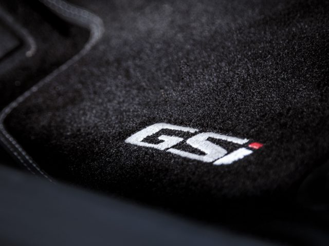 Close-up van een zwarte Opel Insignia-autovloermat met het geborduurde logo "g5" in witte letters en een klein rood detail.