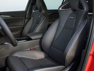 Binnenaanzicht van een Opel Insignia met twee zwartleren sportstoelen met elektronische verstelknoppen aan de zijkant.