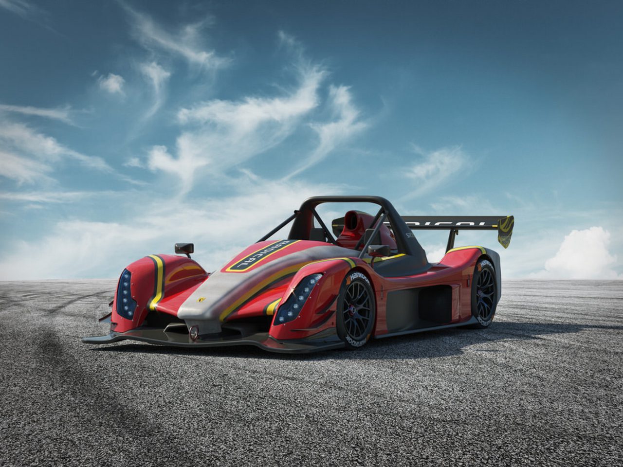 Een radicale, kleurrijke raceauto met een brede achterspoiler geparkeerd op een lege weg onder een helderblauwe hemel.