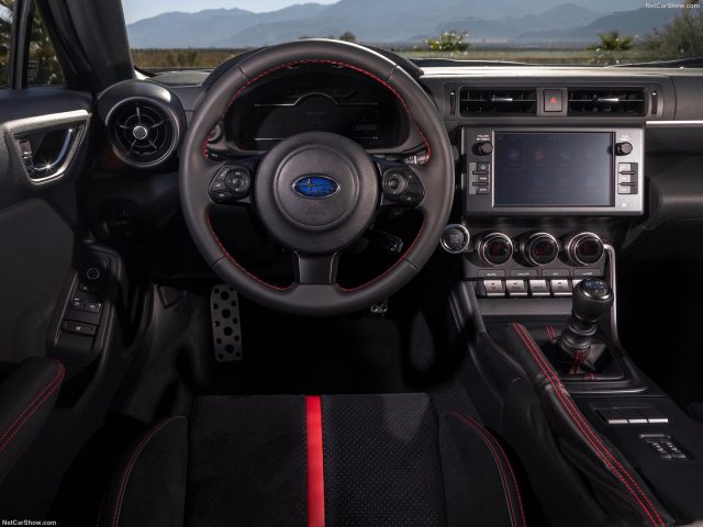 Binnenaanzicht van een Subaru BRZ met het stuur, het dashboard en de middenconsole met rode en zwarte accenten.