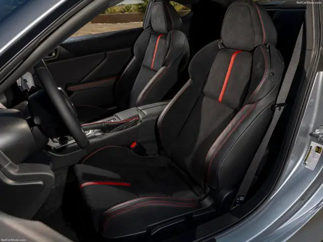 Interieur van een Subaru BRZ met twee voorstoelen met zwarte en rode bekleding, inclusief de versnellingspook en middenconsole.