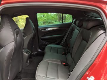 Binnenaanzicht van een Opel Insignia met zwartleren achterbank, een middenarmsteun en deurpanelen met groene bekleding.