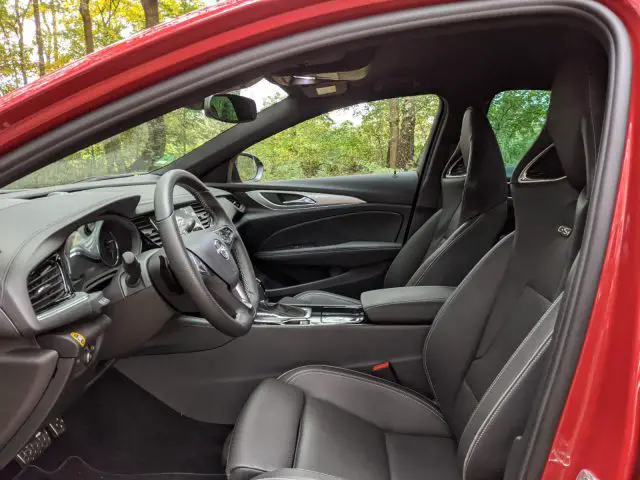 Binnenaanzicht van een Opel Insignia met de bestuurdersstoel, het stuur, het dashboard en het deurpaneel met lederen stoelen.