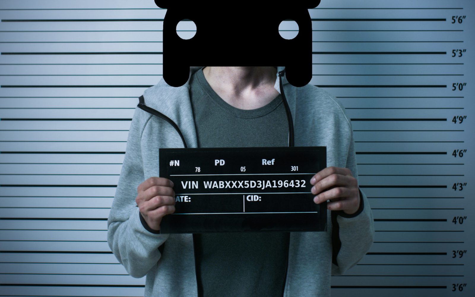 Persoon in een mugshot met een bordje met chassisnummer, staande tegen de achtergrond van een hoogtemeting.