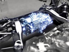 Een holografische projectie van een stadsgezicht afkomstig van een Lexus DIRECT4-motorfiets in een werkplaatsomgeving.