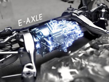 Close-up van de e-ascomponent van een Lexus DIRECT4 elektrisch voertuig, blauw gemarkeerd, terwijl andere mechanische onderdelen zichtbaar zijn in grijstinten.