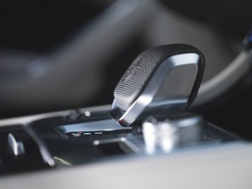 Close-up van de versnellingspook van een Jaguar F-Pace SVR met een strak ontwerp, gelegen op een gepolijste console, met de nadruk op details en textuur.
