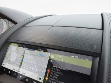 Navigatiescherm voor in de auto met een kaart en verkeersinformatie in een Jaguar F-TYPE, gezien vanaf de passagierszijde met een deel van het dashboard zichtbaar.