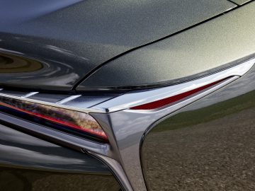Close-up van de achterkant van een Lexus LC 500 Convertible, met de details van het achterlicht en het strakke ontwerp van de kofferbak, met een reflecterende zilveren afwerking.