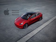 Rode Tesla model 3 geparkeerd op een betonnen ondergrond met een Apple-logo en een gelijkteken ernaast, wat een vergelijking of samenwerking suggereert.