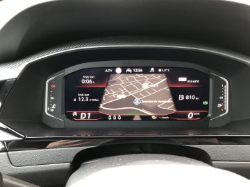 Digitaal autodashboard van de Volkswagen Arteon Shooting Brake met een kaart, navigatiedetails, snelheidsmeter en verschillende voertuigindicatoren.