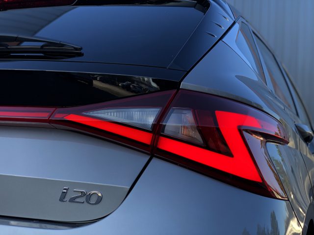 Close-up van de achterkant van een zilveren Hyundai i20, met het gedetailleerde achterlichtontwerp en het "i20"-embleem.