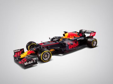 Een Red Bull RB16B Formule 1-auto met een Honda-motor. De auto is voorzien van prominente sponsorlogo's en een zwart-rode kleurstelling.