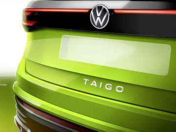Een close-up van de achterkant van een groene Volkswagen Taigo, waarbij de gloeiende achterlichten, het Volkswagen-embleem en het 'TAIGO'-embleem op deze stijlvolle SUV goed uitkomen.