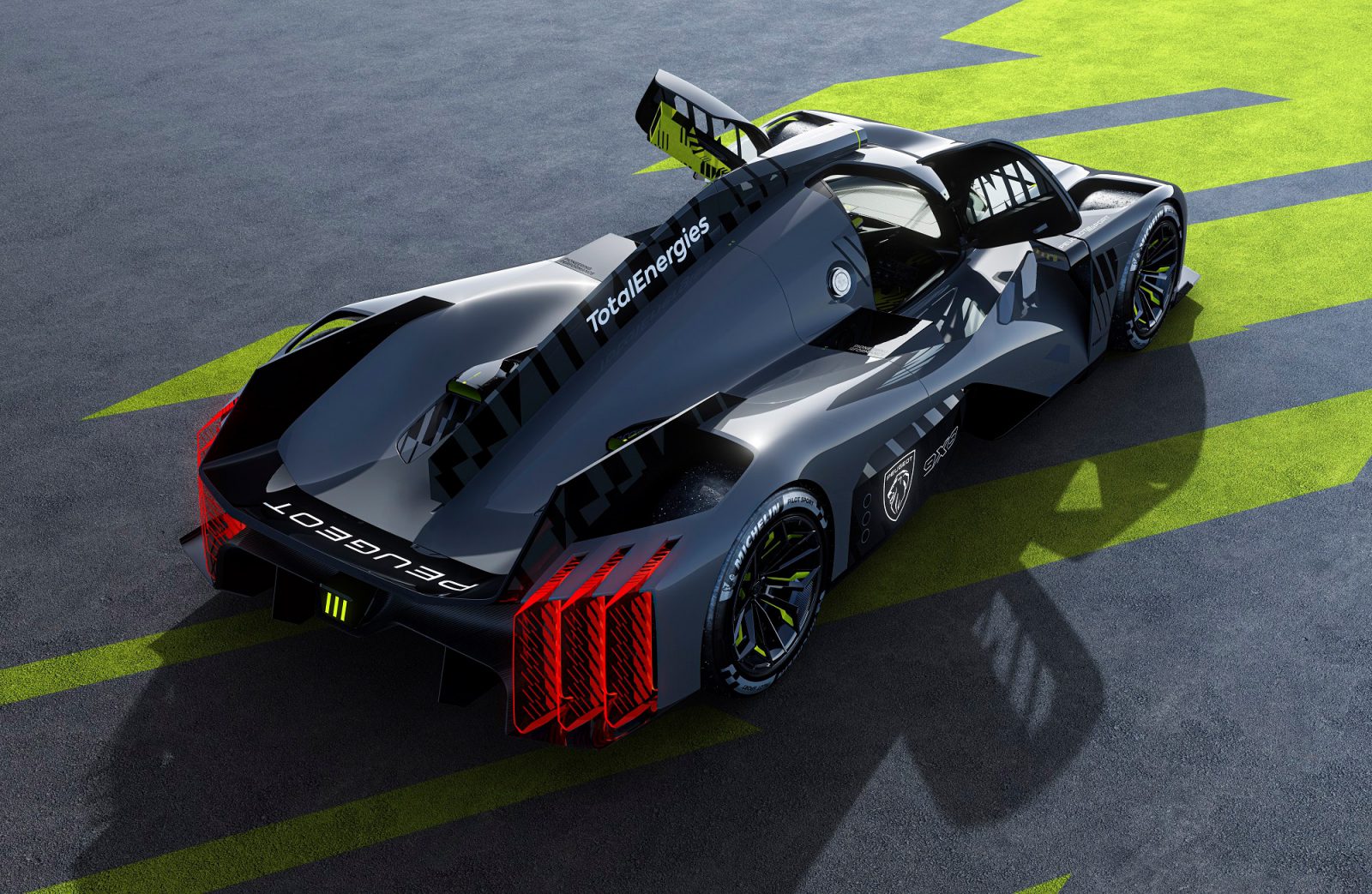 Een krachtige, gestroomlijnde Peugeot 9X8-raceauto met een futuristisch ontwerp en een opvallende achtervleugel, gepositioneerd op een grijs oppervlak met groene geometrische patronen.