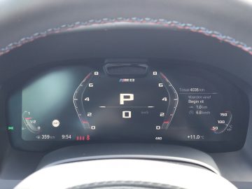 Een strak digitaal dashboard in de BMW M8 Gran Coupé Competition toont verschillende meetgegevens, waaronder een toerenteller, snelheidsmeter, kilometertellerstand 4036 km, brandstofmeter, tijd op 9:54, temperatuur op 11°C en rijbereik van 359 km.