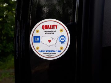 Sticker op zwarte achtergrond met de tekst "QUALITY From the Heart of America" met een kaart van de logo's van de VS, GM en UAW, de tekst "Fairfax Assembly Plant Kansas City, Kansas" en een vermelding van de Cadillac XT4.