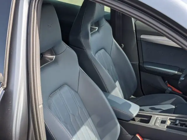 De afbeelding toont de voorstoelen van een modern Cupra Formentor-interieur, voorzien van zwart lederen bekleding met stiksels en een middenconsole.